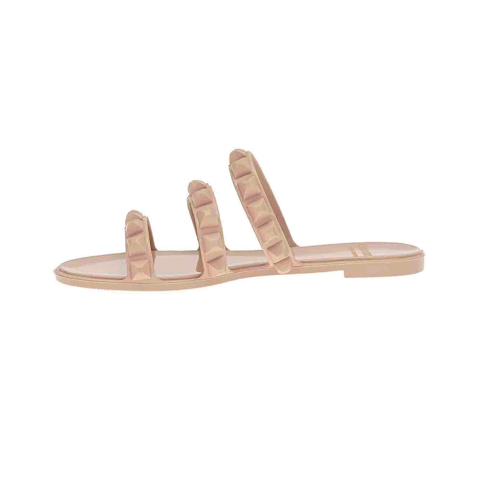 Blush Maria 3 strap flat jelly sandals from Carmen Sol are in vibrant colors, perfect for beach and vacation enthusiasts. The sandals are laid out against a sandy beach backdrop with the ocean waves gently rolling in.