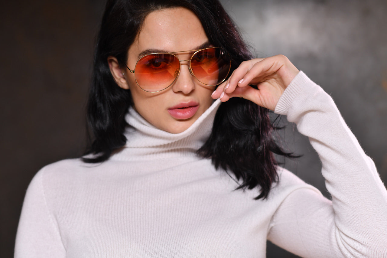Women wearing Carmen Sol turtleneck cashmere sweater in color white along with sunglasses in red