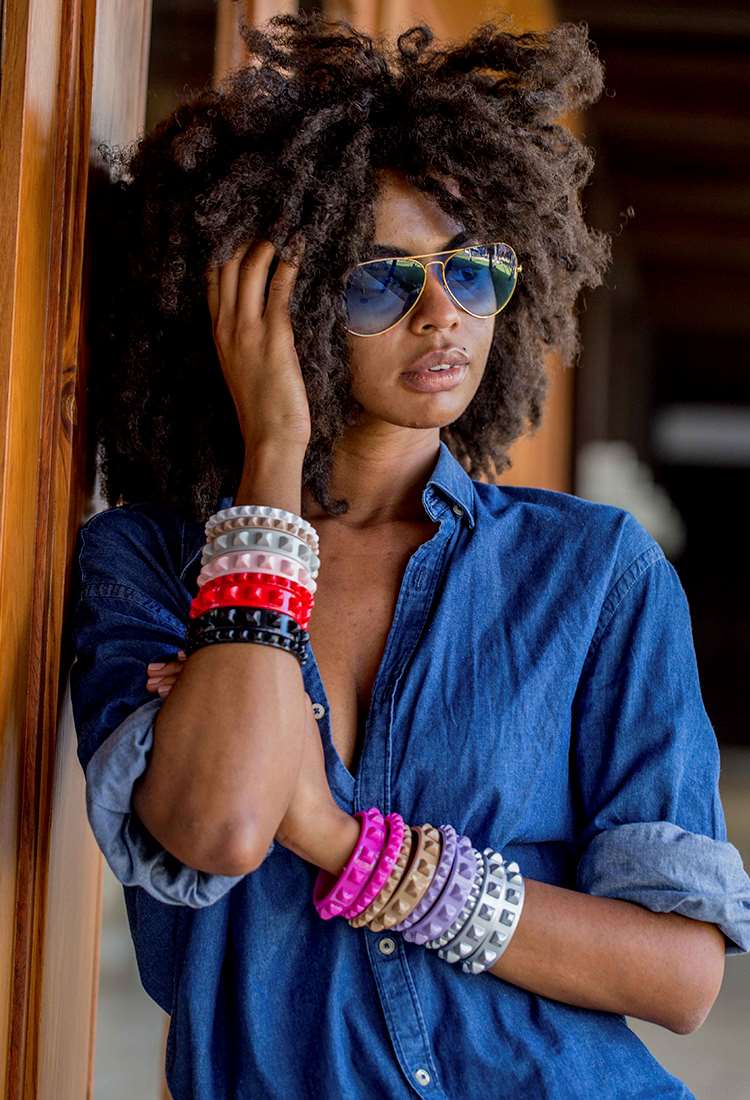 Girl wearing stackable bracelets multi color in jelly material and aviator sunglasses in color gold