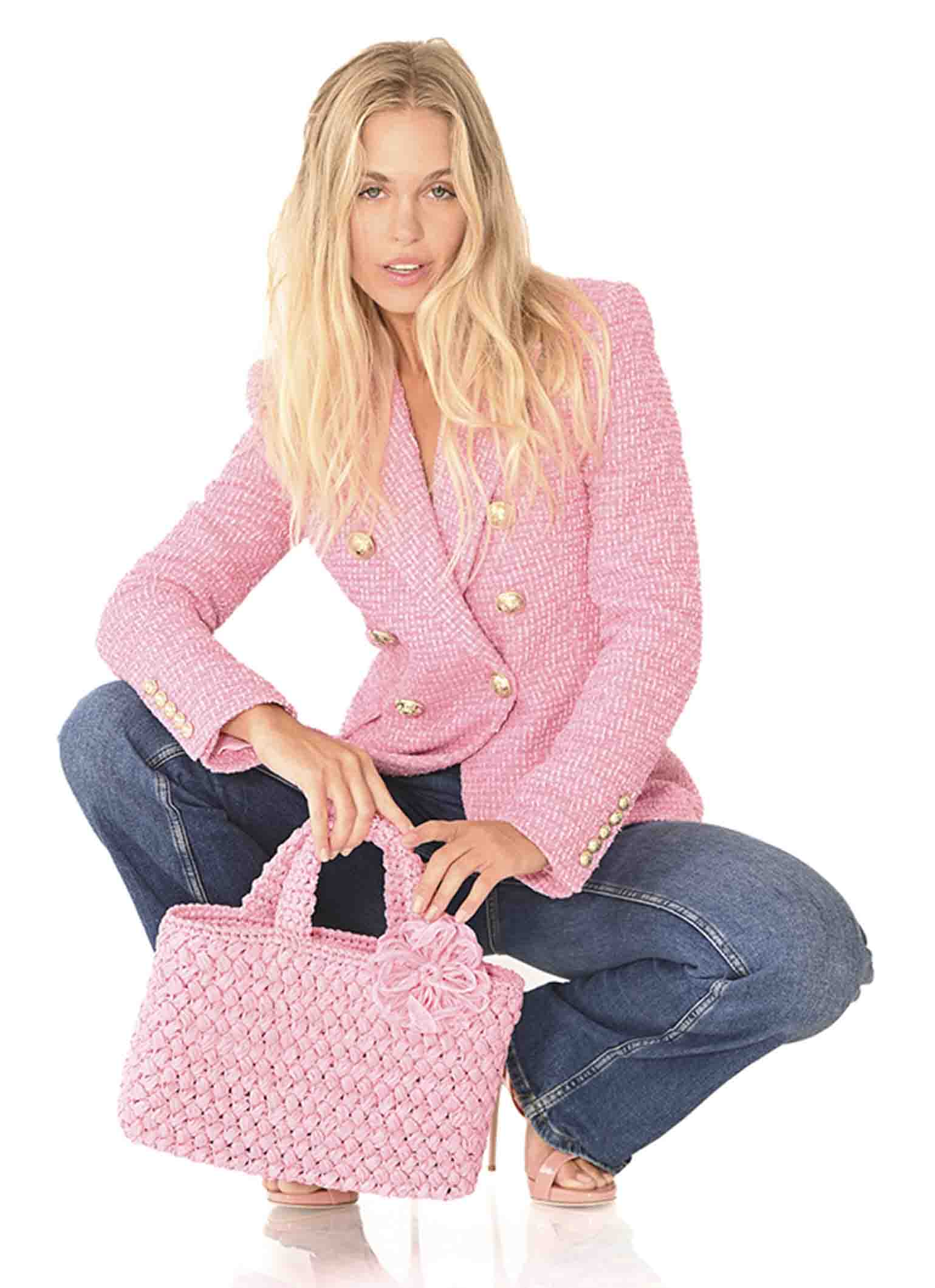 Women with baby pink Positano Raffia Small Bag a versatile accessory for both beach outings and shopping sprees from Carmen Sol