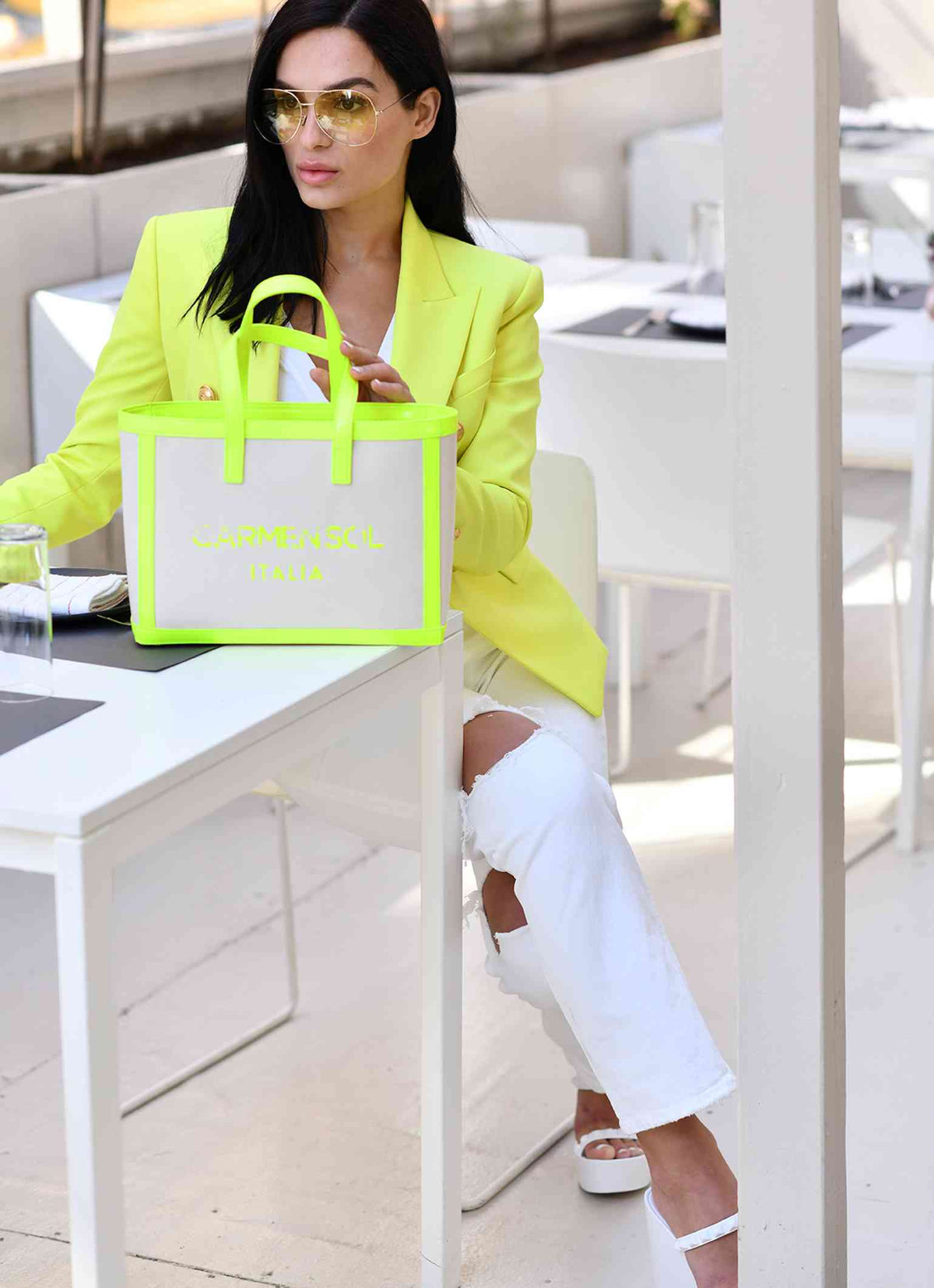 Woman wearing Carmen Sol mini canvas beach bags for women in color neon yellow