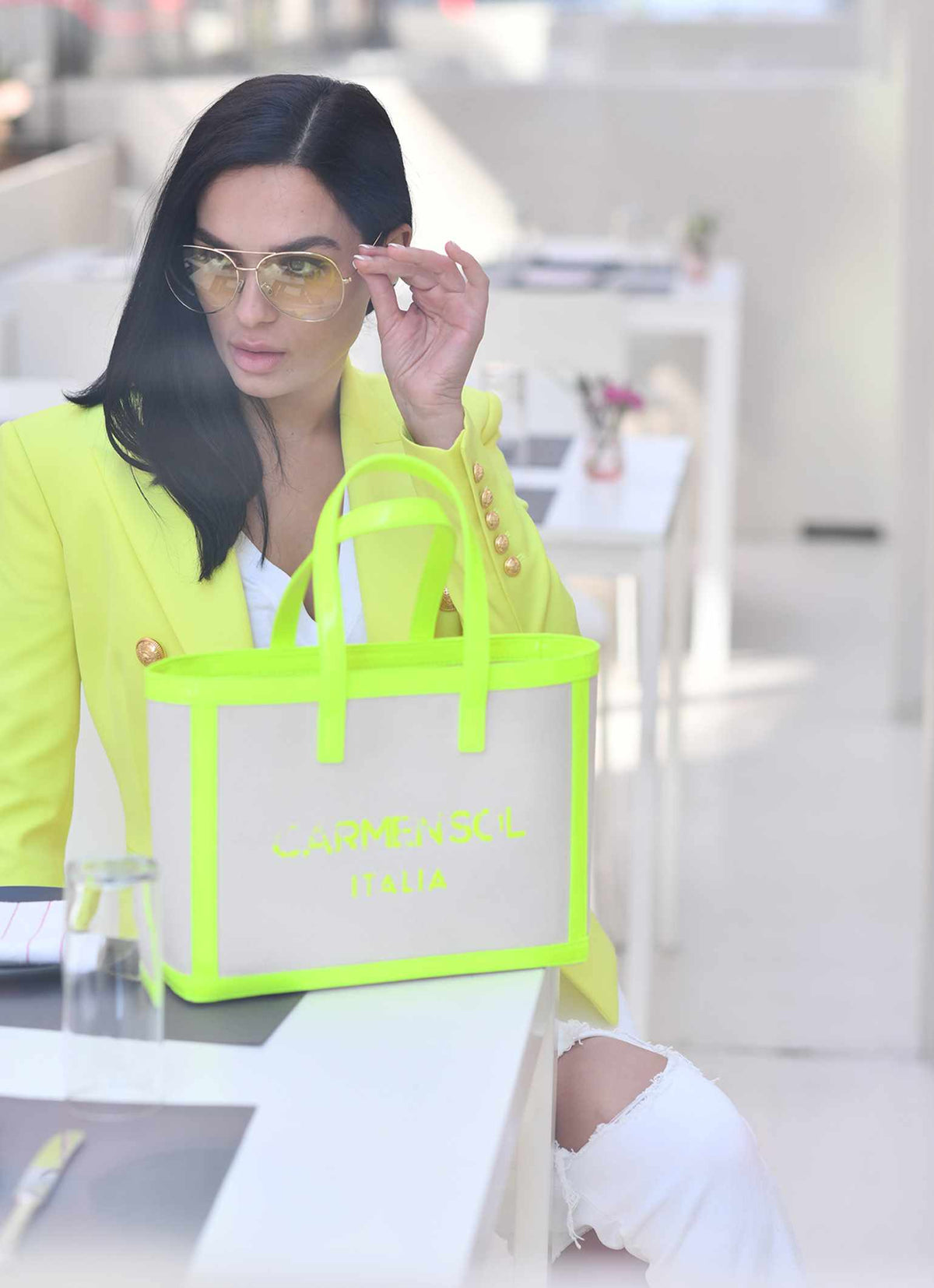 Woman carrying matching Carmen Sol canvas beach purse in color neon yellow with sunglasses