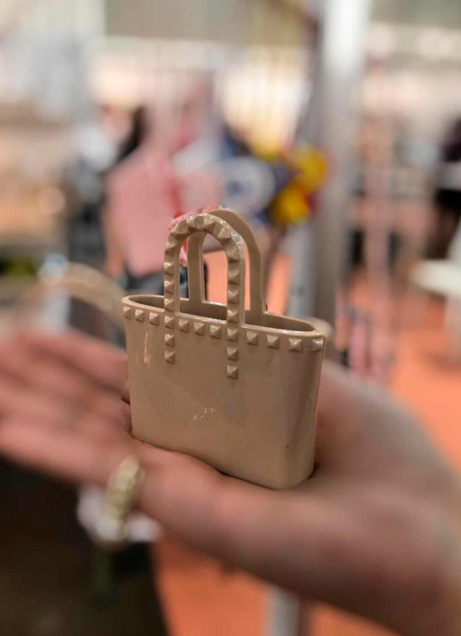 Women placing the Itsy Bitsy bag charms in color nude in her hand