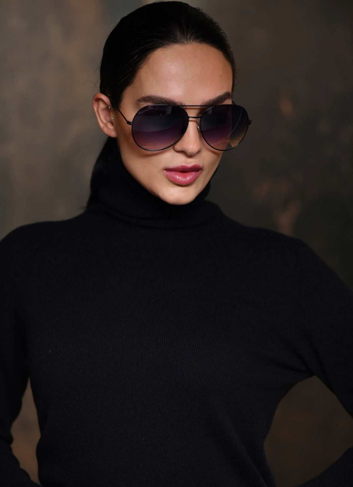 Women wearing black turtle neck cashmere in color black and matching black aviator sunglasses 