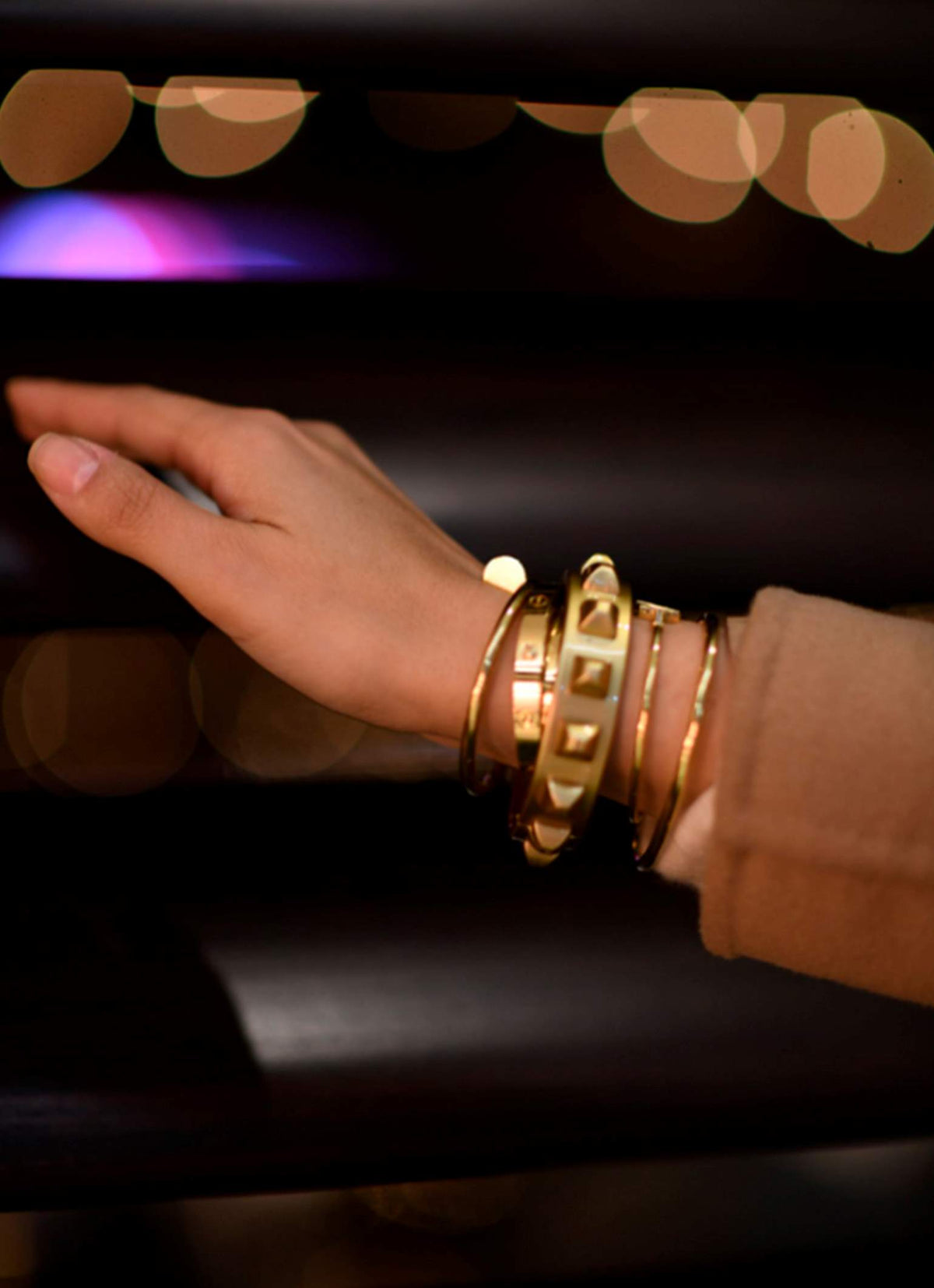 Gold bracelets for women worn with Cartier Love bracelets and Van Cleef
