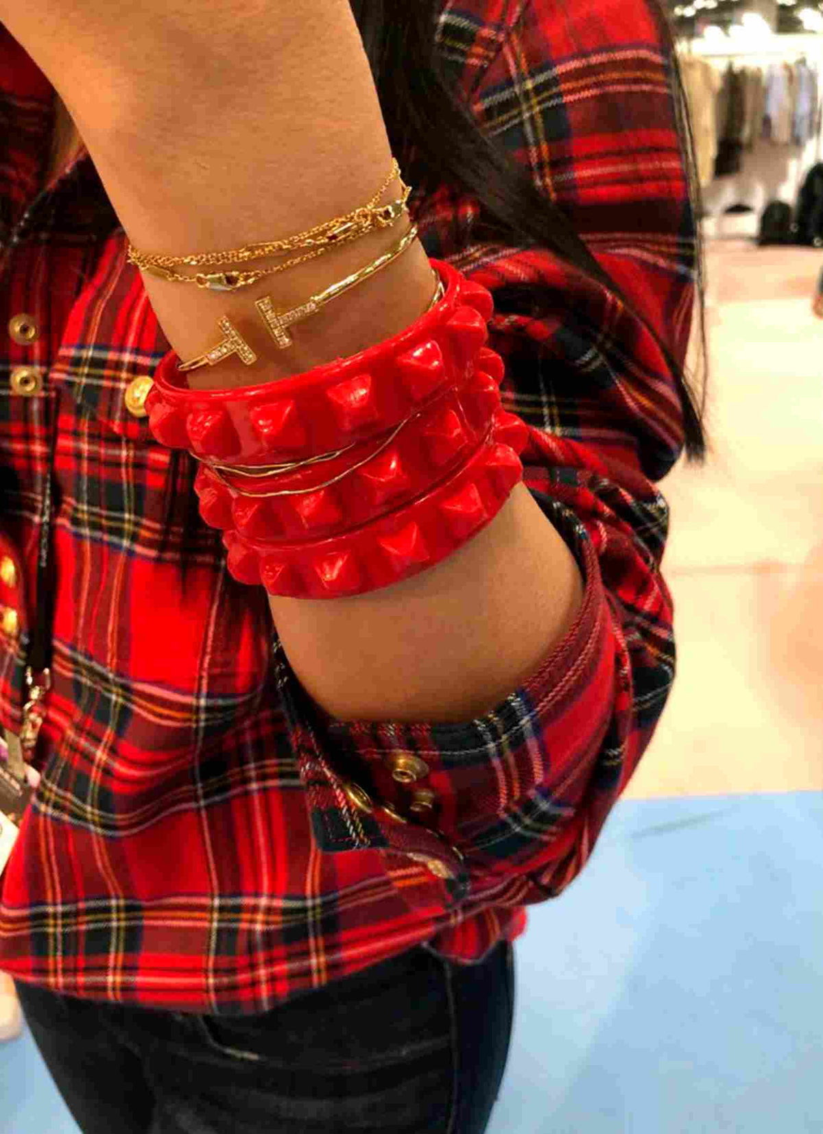 Gold bracelets and jelly bracelets in red stackable with Cartier bracelets