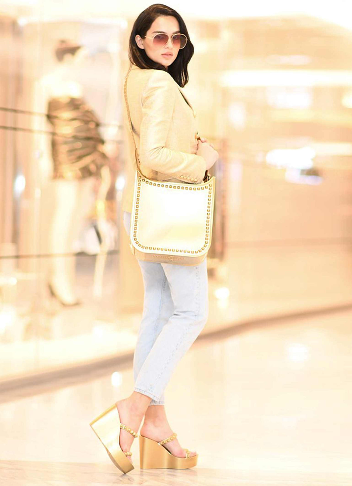 Fico gold jelly bag from Carmen Sol paired with gold wedges