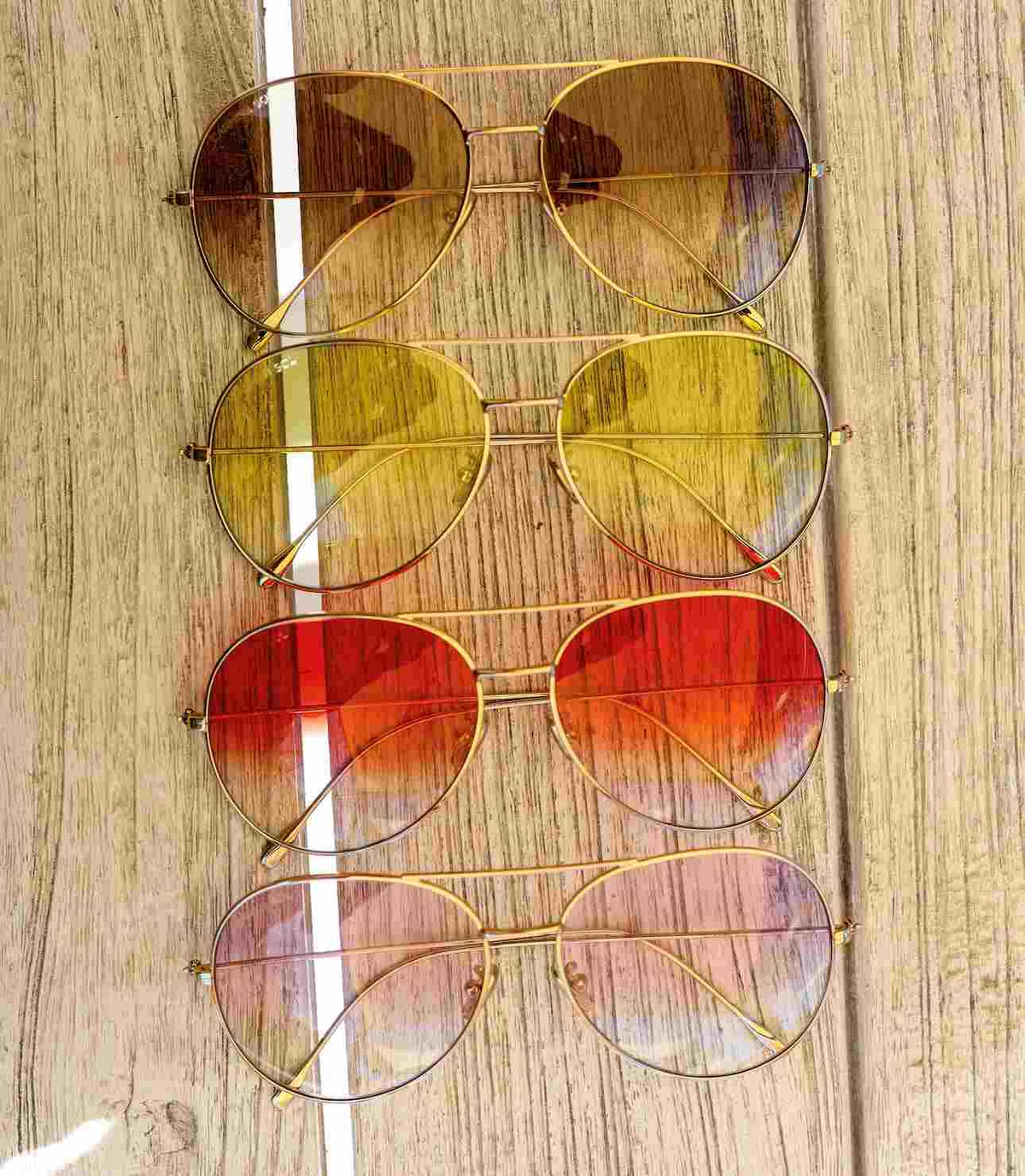 Gold aviator with various gradient lenses colors brown yellow red violet on a table